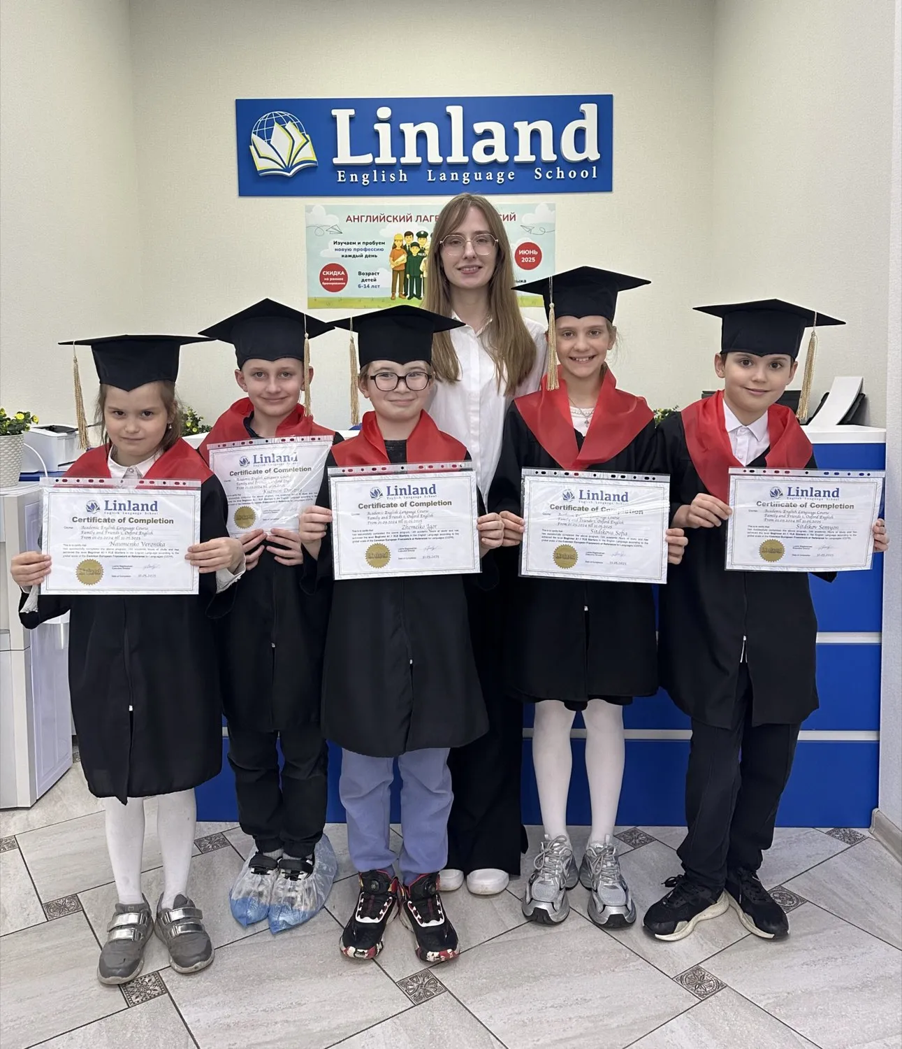 Выпускники Linland в академических шапочках с сертификатами